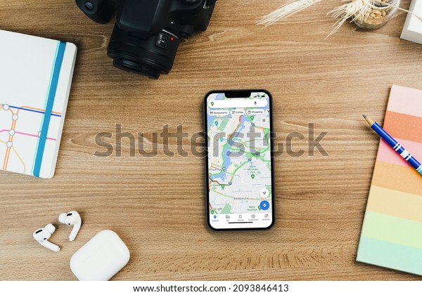 Google Maps app on the smartphone screen on wooden\
background. Office environment. Rio de Janeiro, RJ, Brazil.\
December 2021.