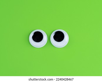 googly  cute eyes funny Isolated on bright lime green  background copy space logo