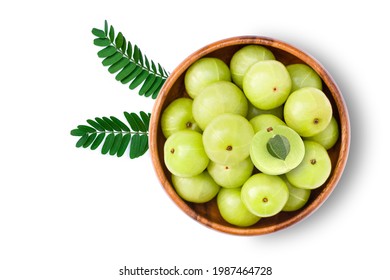 Gooseberry fruits (phyllanthus emblica, amla) in wooden bowl with green leaf and sliced isolated on white background. Top view. Flat lay.