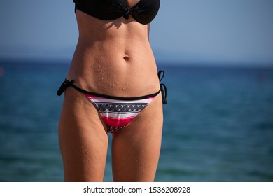 Goosebumps And Drops Of Water On The Female Skin. Close Up Fit Woman Body At The Beach. Woman Hips And Stomach 
