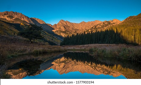 The Gore Range Reflecting In Stream Near Vail, Colorado.