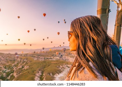 Goreme Cappadocia Turkey July 2018, hot air balloons during Sunrise over the fairytale landscape hills of Kapadokya, young woman in hot air balloon