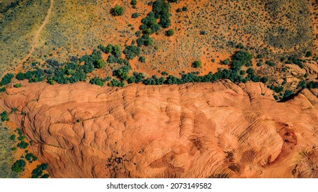 Gorgeous aerial drone top bird's eye view of incredible red petrified sand dunes with green foliage in the desert of the Snow Canyon State Park in Southern Utah