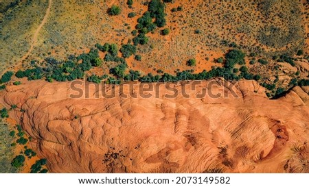 Gorgeous aerial drone top bird's eye view of incredible red petrified sand dunes with green foliage in the desert of the Snow Canyon State Park in Southern Utah