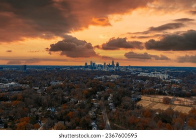 a gorgeous aerial shot of the downtown cityscape with skyscrapers and vast miles of autumn colored trees with blue sky and clouds at Freedom Park in Charlotte North Carolina USA	
