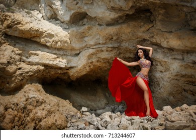 Gorgeous arabian woman bellydancer dancing in white bellydance costume outdoors in Egypt desert. Sexy turkish belly dancer posing in bridal baladi dress with jewelry