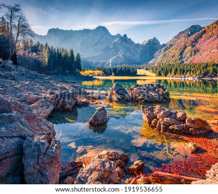 Gorgeous autumn view of Fusine lake. Calm morning scene of Julian Alps with Mangart peak on background, Province of Udine, Italy, Europe. Traveling concept background.