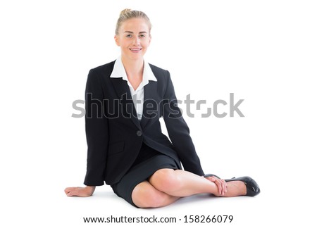 Gorgeous blonde businesswoman sitting on the floor smiling at camera