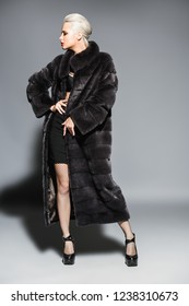 Gorgeous blonde woman posing in luxurious fur coat. Fashion, beauty. Studio shot.