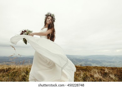 Gorgeous Bride Dancing And Having Fun Holding Dress, Boho Wedding, Luxury Ceremony At Mountains