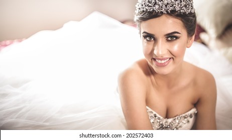 Gorgeous Bride Portrait In Her Wedding Dress Wearing Tiara. Beautiful Bridal Makeup And Hairstyle And Hair Accessories. Bride To Be Smiling Portrait