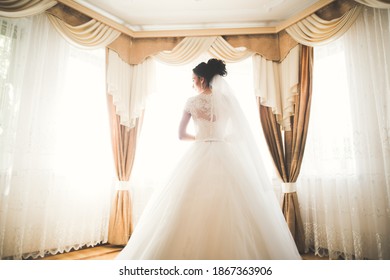 Gorgeous bride in robe posing and preparing for the wedding ceremony face in a room