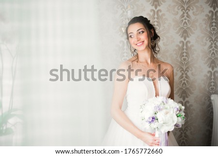 Gorgeous bride in robe posing and preparing for the wedding ceremony face in a room