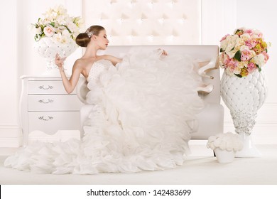 Gorgeous bride standing on sofa