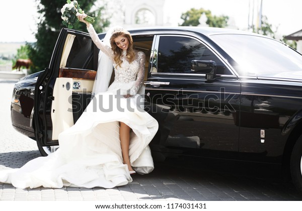 Gorgeous bride steps\
out of a rich black\
car