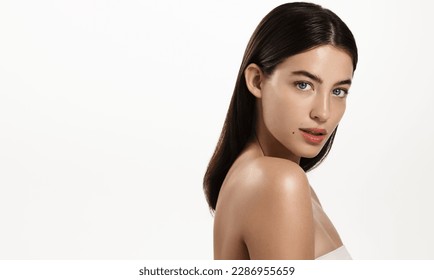 Gorgeous brunette woman with blue eyes, clear glowing skin, perfect shiny body after spa effect, doing nourishing skincare routine, spa at home, standing over white background.