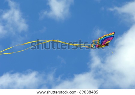 Gorgeous butterfly kite soars against a vivid blue sky at the Cape Charles, Virginia beach front park.  Butterfly wings are spread and a yellow tail stabilizes kite.