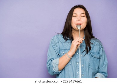 Gorgeous caucasian woman in her 30s eating delicious food with a spoon and enjoying dessert - Powered by Shutterstock