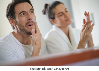   Gorgeous Couple Going Through Daily Beauty Regime In Bathroom                             