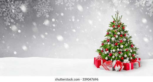 Gorgeous elegant Christmas tree with gifts in red and silver on a panoramic snow background