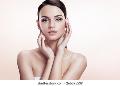 Gorgeous Fashion Model On Beige Background. Youth And Skin Care Concept.