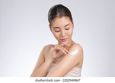 Gorgeous girl with soft makeup applying moisturizing skincare cream on shoulder isolated over white background. Skincare cream applied by female model concept. - Shutterstock ID 2202949847