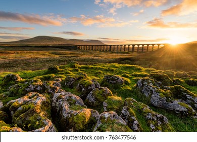 Gorgeous golden light as the sun sets behind the Ribblehead Viaduct with rocks in foreground. - Powered by Shutterstock