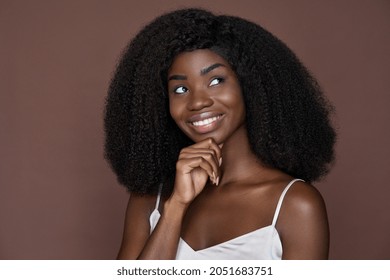 Gorgeous Happy Playful Unusual Beautiful Young African Black Woman Looking Up Touching Face Thinking Isolated On Brown Background. Headshot Closeup Portrait. Skincare Beauty Cosmetology Concept.