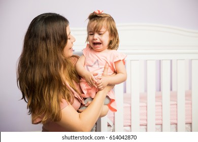 Gorgeous Hispanic Woman Trying To Make Her Angry Child Stop Crying In The Nursery 