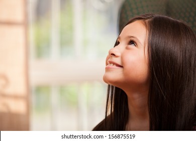 Gorgeous Little Girl Smiling And Looking Up Towards Copy Space