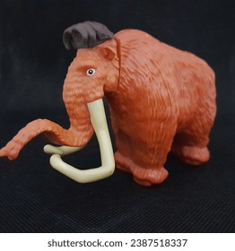 a gorgeous mammoth toy against a black background, elephant