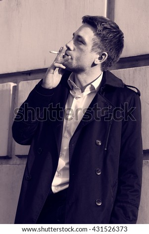 Similar – young guy in a shirt smokes on the street