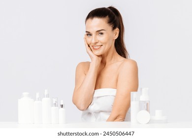 Gorgeous middle aged woman touching her perfect skin. Beautiful portrait of a 40-50 year old woman advertising anti-aging facial products, salon care, skin tightening, isolated on white background. - Powered by Shutterstock