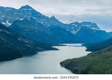 The gorgeous mountains of Waterton Lakes National Park, Canada. Photographed early in the morning to capture the blue color cast on the mountains, snow-capped mountains, hazy conditions, and overcast  - Powered by Shutterstock