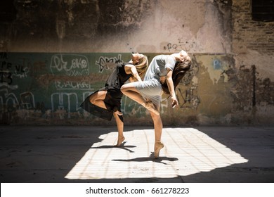 Gorgeous pair of female dancers performing together and synchronized outdoors in an urban setting - Powered by Shutterstock