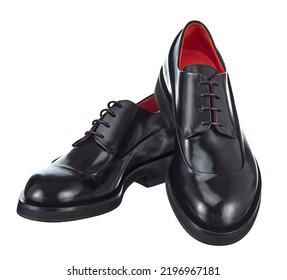 Gorgeous pair of men's derby shoes made of glossy black leather, lace-up, standing on top of each other, with beautiful highlights on the surface, isolated on a white background.