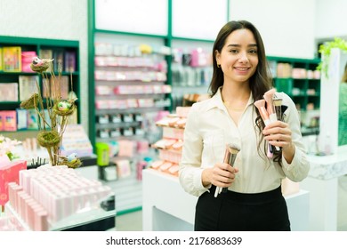 Gorgeous salesperson showing the new makeup brushes while selling products at the store
