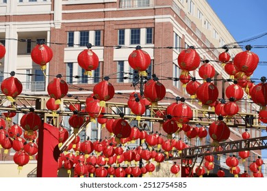 a gorgeous shot of rows of red Chinese lanterns hanging from black cables with a blue sky background at Atlantic Station in Atlanta Georgia USA - Powered by Shutterstock