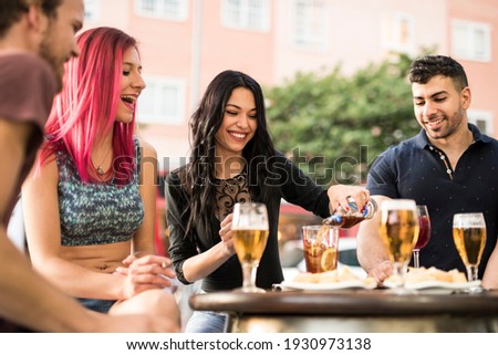 gorgeous Spanish women smokes cigar and drinks beer on the terrace of a bar