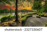 A gorgeous spring landscape along the Chattahoochee River with lush green trees, grass and plants and colorful flowers with powerful clouds at sunset at Ray’s on the River in Sandy Springs Georgia