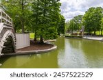 a gorgeous spring landscape at Louis Armstrong Park with lush green trees, plants and grass, a lake, blue sky and clouds in New Orleans Louisiana USA