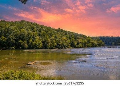 a gorgeous summer landscape along the Chattahoochee river with flowing water surrounded by lush green trees, grass and plants with powerful clouds at sunset in Atlanta Georgia USA	 - Powered by Shutterstock