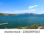 gorgeous summer landscape at the lake with deep blue water and lush green mountains ranges and blue sky at Diamond Valley Lake in Hemet California USA	