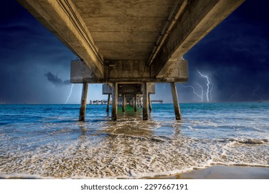 a gorgeous summer landscape at Long Beach City Beach along the Belmont Veterans Memorial Pier with blue ocean water, brown sand, waves and storm clouds and lightning in Long Beach California USA - Powered by Shutterstock