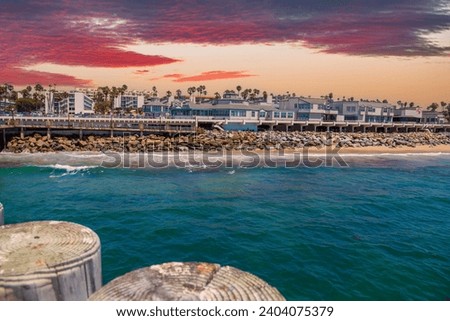 a gorgeous summer landscape at the Redondo Beach Pier with restaurants and retail stores along the pier, blue ocean water and powerful clouds at sunset in Redondo Beach California USA 