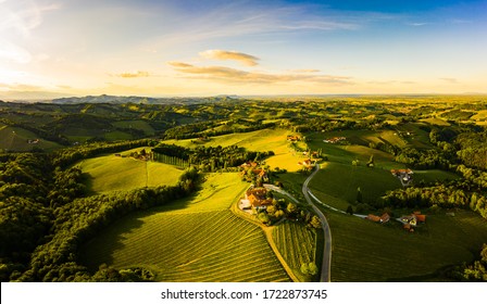 Gorgeous Sunset Over Beautiful Green Vineyards. Aerial Panorama Sunset Over Austrian Grape Hills In Spring. Wine Culture In South Styria, Tuscany Like Tourist Famous Spot.