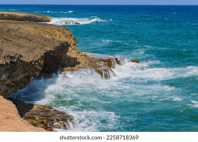 Gorgeous view of big turquoise waves of Atlantic Ocean rolling on rocky coast of island of Aruba.