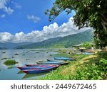 Gorgeous view of boats on lake, Pokhara Nepal with stunning cloudscape. High quality photo