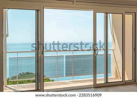 Gorgeous view from the hotel room through the panoramic window to the sea on a sunny warm summer day with blue skies in a luxury resort. Copyspace