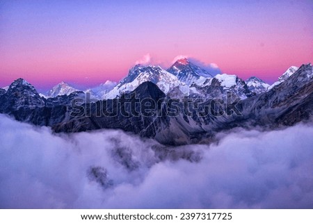 Gorgeous view of Mount Everest's snow covered peak beneath a blanket of white clouds